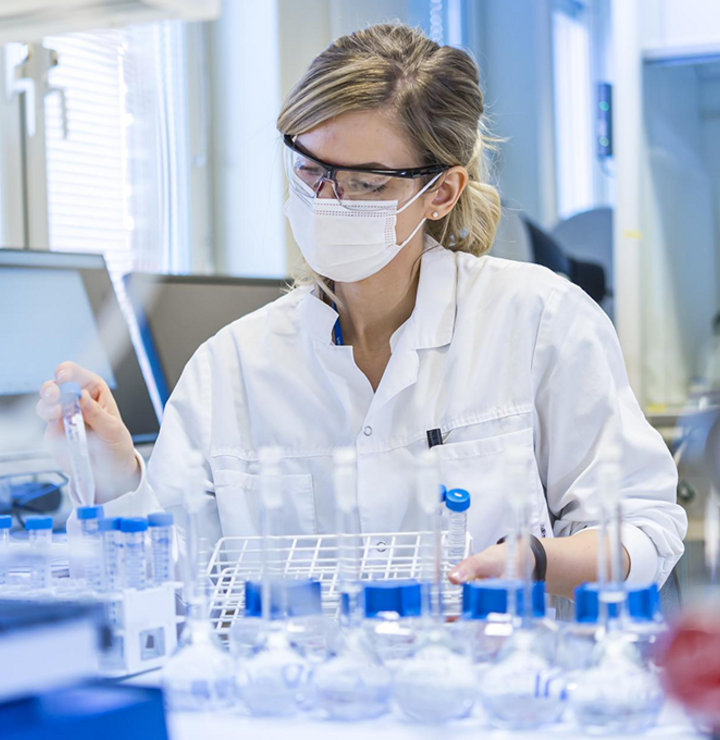 A blonde woman working in the laboratory holding test probes